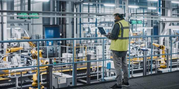 Car,Factory,Engineer,In,High,Visibility,Vest,Using,Laptop,Computer.