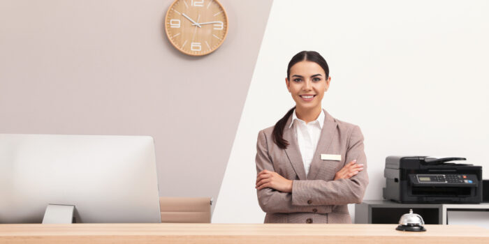 Portrait,Of,Receptionist,At,Desk,In,Modern,Hotel