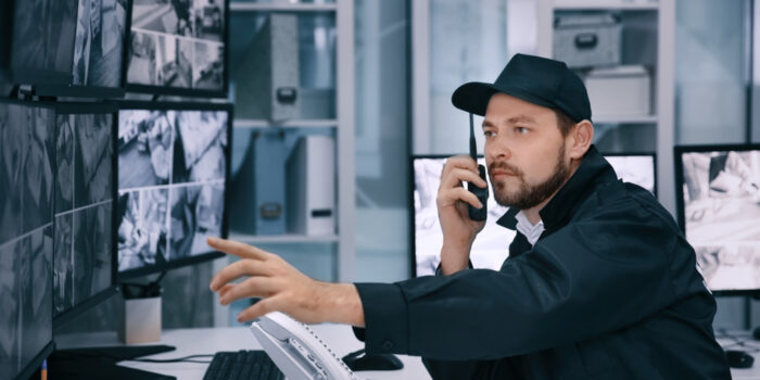 Male,Security,Guard,Using,Radio,Transmitter,In,Surveillance,Room