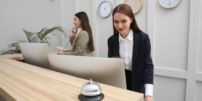 Beautiful,Receptionists,Working,At,Counter,In,Hotel